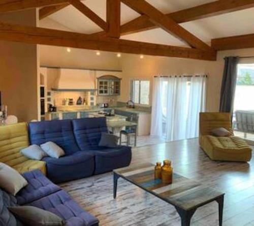 a living room with a blue couch and a table at Jolie Maison Jardin Piscine in Narbonne