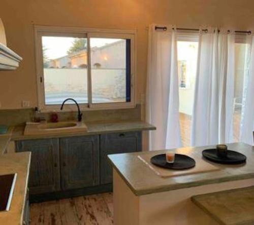 a kitchen with two black plates on a counter at Jolie Maison Jardin Piscine in Narbonne