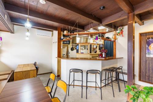 - une cuisine et une salle à manger avec un comptoir et des tabourets dans l'établissement 長濱元浜町宿場　片原楽家, à Nagahama