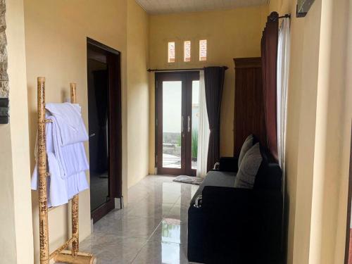 a living room with a couch and a mirror at Ayodya Batur Villa in Kintamani