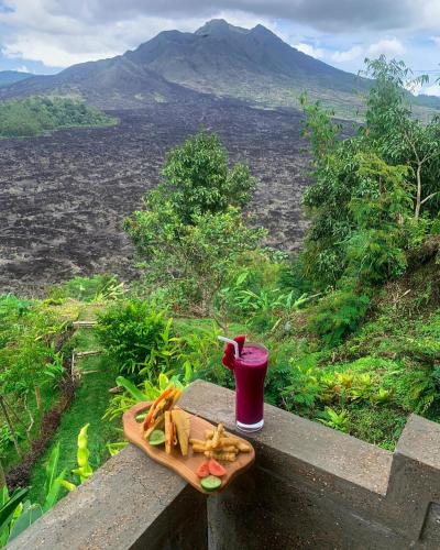 a tray of food on a table with a drink at Ayodya Batur Villa in Kintamani