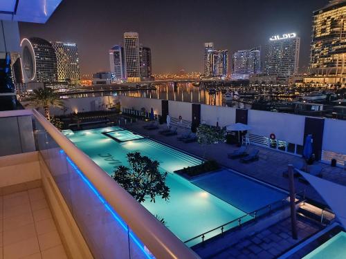 una piscina en la azotea de un edificio por la noche en OSKENA Vacation Homes - Waterfront Downtown, en Dubái
