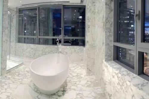 a bathroom with a white tub in a room with windows at Puerto Madero Apartamento Piso Entero de 650m2 Panorámico y Sofisticado in Buenos Aires