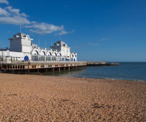 a building on a pier next to the beach at #4 The Quirky Quarters in Portsmouth