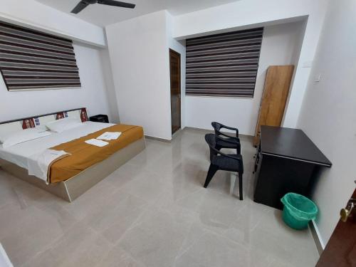 a bedroom with a bed and a desk in it at Karthika Homes in Anachal