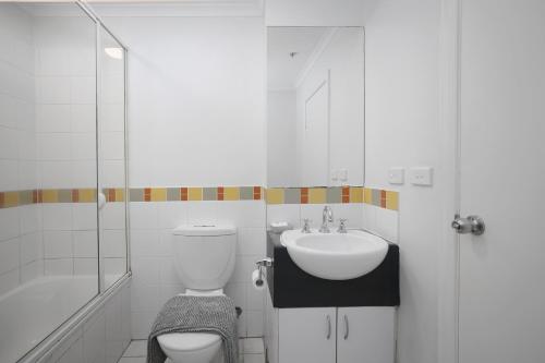 La salle de bains blanche est pourvue de toilettes et d'un lavabo. dans l'établissement Vintage Charm 2 Bed Apt Near Flinders Station, à Melbourne