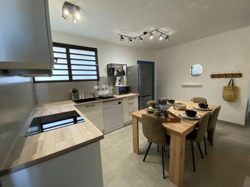 eine Küche mit einem Holztisch und einem Esszimmer in der Unterkunft La Kaz Leu tit'mer à 50 m du lagon de Saint-Leu in Saint-Leu