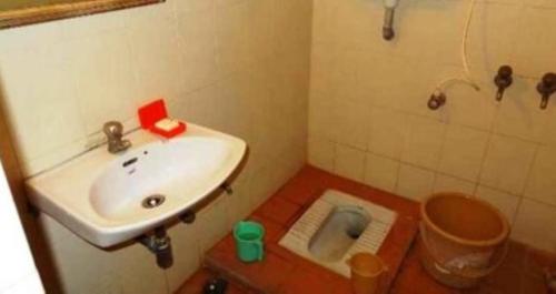 a small bathroom with a sink and a toilet at Hotel Sambodhi International, Madhya Pradesh in Sānchi