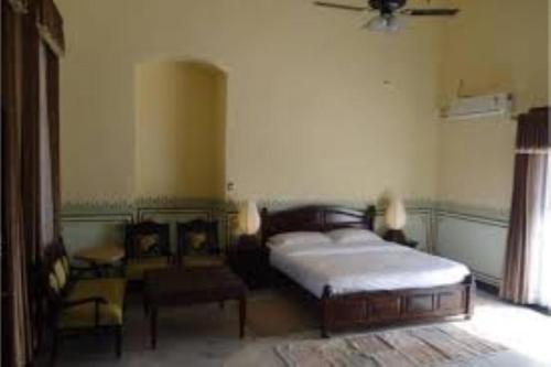 ein Schlafzimmer mit einem Bett und einem Stuhl darin in der Unterkunft Hotel Sambodhi International, Madhya Pradesh in Sānchi