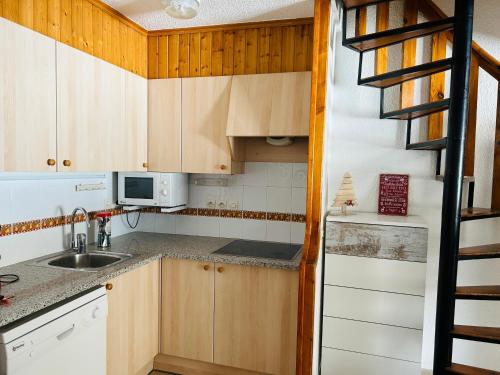 a small kitchen with wooden cabinets and a staircase at MIKKA FRONTERA DUPLEX PISTAS in Pas de la Casa
