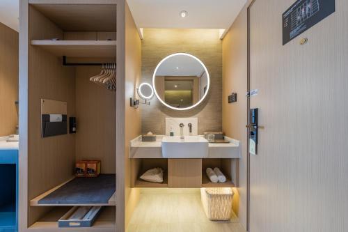 a bathroom with a sink and a mirror at Atour Hotel Hefei USTC Huangshan Road in Hefei