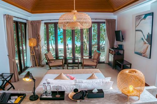 a living room with a white couch and a table at Victoria Cliff Resort Nyaung Oo Phee Island in Nga Khin Nyo Gyee Island