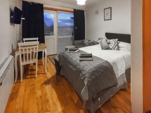 a bedroom with a bed and a table and a dining room at Hynish House in Stornoway