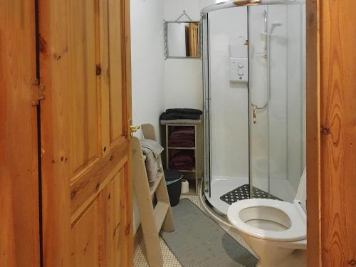 a bathroom with a toilet and a glass shower at Hynish House in Stornoway