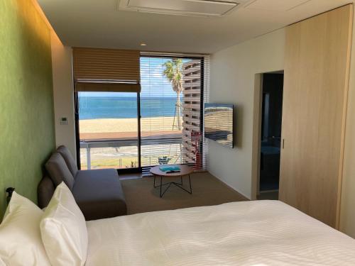 Solasuna في Yukuhashi: غرفة نوم بسرير وإطلالة على الشاطئ