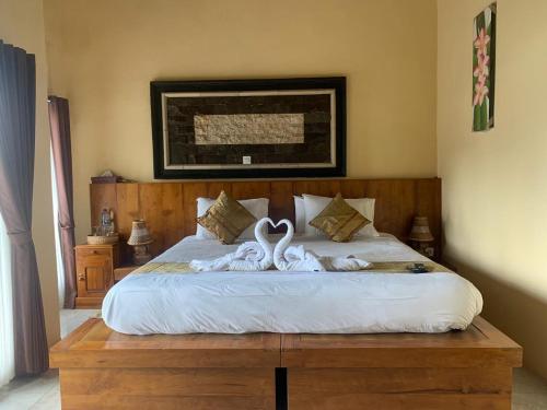two white swans are sitting on a bed at Ayodya Batur Villa in Kintamani