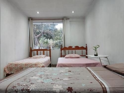 sypialnia z 2 łóżkami i oknem w obiekcie ¡Hermosa casa de campo rodeada de naturaleza! w mieście Lunahuaná