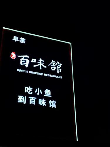a sign with chinese writing on it in the dark at Fortune Land Shenzhen in Shenzhen