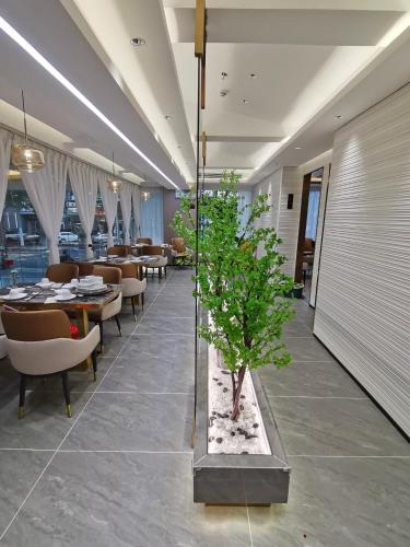 a restaurant with tables and chairs and a tree in the middle at Fortune Land Shenzhen in Shenzhen