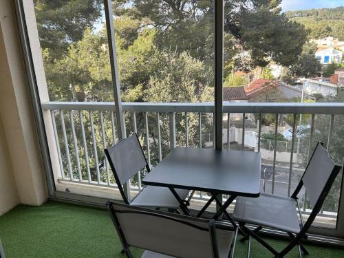 a table and chairs in front of a balcony at Studio Pin Rolland, presqu’île Saint-Mandrier in Saint-Mandrier-sur-Mer