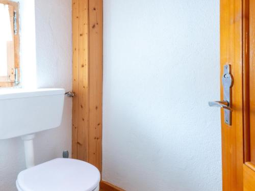 a bathroom with a white toilet and a wooden door at Apartment in Vorarlberg near Ski Resort Montafon in Sankt Gallenkirch