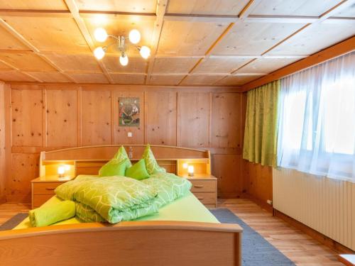 a bedroom with a bed with green pillows at Apartment in Vorarlberg near Ski Resort Montafon in Sankt Gallenkirch