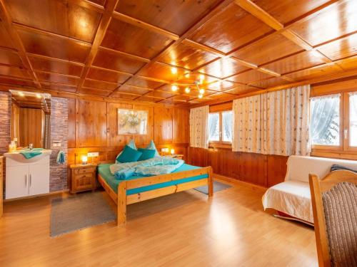 a bedroom with a bed and a chair in a room at Apartment in Vorarlberg near Ski Resort Montafon in Sankt Gallenkirch