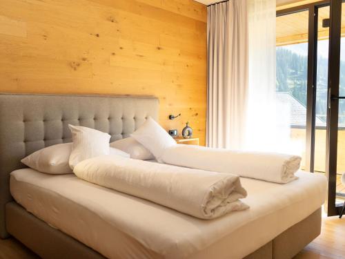 2 poduszki na łóżku w pokoju z oknem w obiekcie My Heimat 1495 Arlberg w mieście Schröcken
