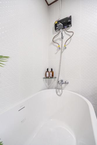 a bathroom with a white tub and a blow dryer at MIQ HK16, Huay Kwang MRT, 3BR, Pool Table in Ban Zong Katiam