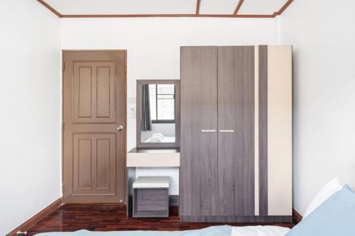 a bedroom with a wooden cabinet and a mirror at MIQ HK16, Huay Kwang MRT, 3BR, Pool Table in Ban Zong Katiam