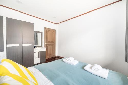 a bedroom with a bed with two towels on it at MIQ HK16, Huay Kwang MRT, 3BR, Pool Table in Ban Zong Katiam