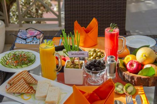 a table topped with plates of food and fruit at Yog Wellness Resort & Spa By Amritara in Mussoorie