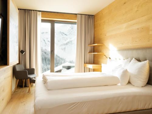 two beds in a hotel room with a window at My Heimat 1495 Arlberg in Schröcken