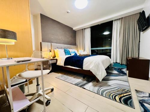 a hotel room with a bed and a desk and a desk at Executive Queen 1BR Luxury Suite 10 - Pool, Wi-Fi in Manila