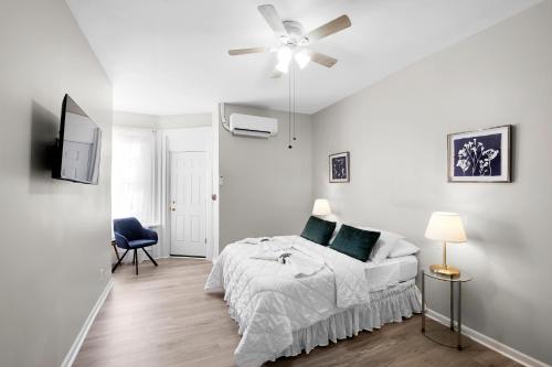 a white bedroom with a bed and a ceiling fan at Lovely 2br In Univ City in Philadelphia