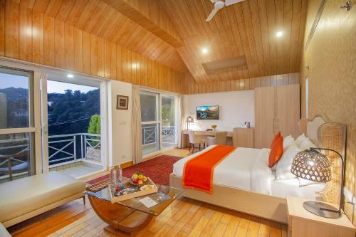 um quarto com uma cama grande e uma varanda em Yog Wellness Resort & Spa By Amritara em Mussoorie