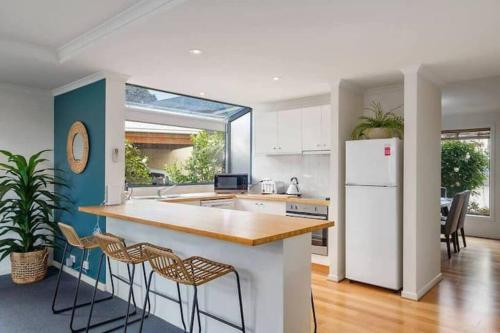 a kitchen with a white refrigerator and some chairs at Tranquil Howrah Townhouse in Howrah