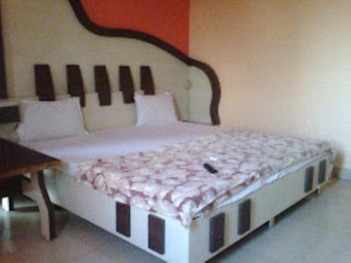 a bedroom with a bed with a wooden headboard at Hotel Rajawat , Madhya Pradesh in Vidisha