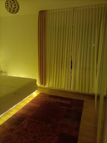 a living room with a couch and a window with curtains at Double room in Bielefeld