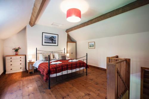 ein Schlafzimmer mit einem Bett mit einer roten Decke in der Unterkunft Cabalva Mill Cottage - very private and with views over the River Wye in Clifford
