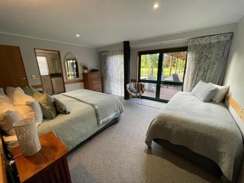 a bedroom with two beds and a large window at Tikitere Lodge, Rotorua in Rotorua