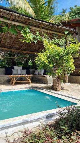 a swimming pool in front of a house at Coconut Cottage - Hiriketiya Beach in Hiriketiya