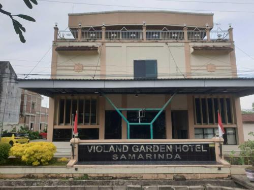 ein Hotel mit einem Schild vor einem Gebäude in der Unterkunft Violand Garden Hotel Samarinda in Samarinda