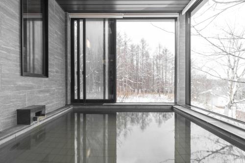a room with a pool of water in front of a window at Villa Yin Niseko in Kutchan