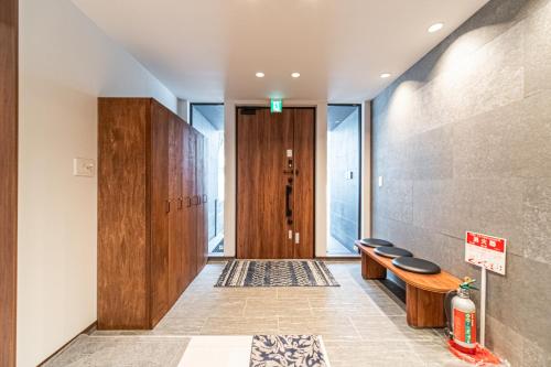 un couloir avec une rangée de bancs et une porte dans l'établissement Villa Yin Niseko, à Niseko