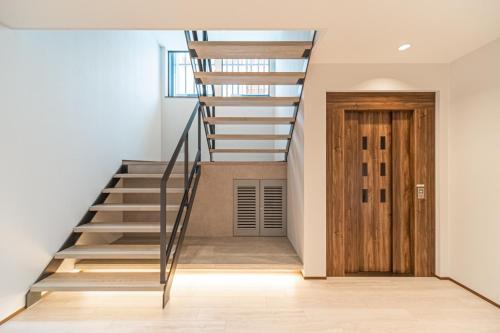 a staircase in a house with a wooden door at Villa Yin Niseko in Kutchan