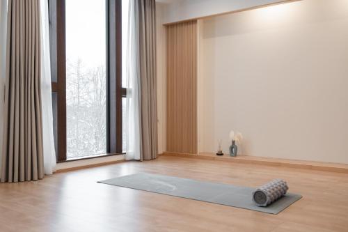 a yoga mat on the floor in a room with a window at Villa Yin Niseko in Kutchan