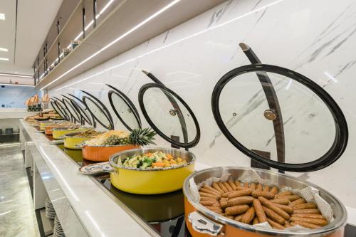 a buffet line with bowls of food on a counter at Atour Hotel Hefei USTC Huangshan Road in Hefei