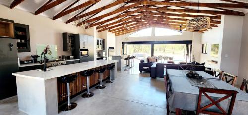 cocina y sala de estar con barra y mesa en Elements Private Golf Reserve 109 & 111, en Moheme
