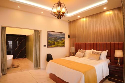 a bedroom with a bed and a bathroom with a tub at Misty Wonders in Munnar